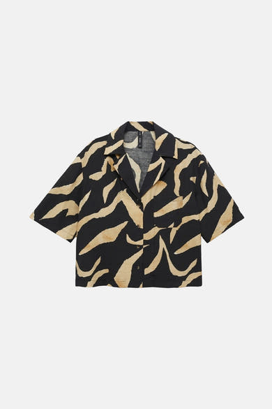 Chemisier à manches courtes noir à motifs zébrés, de MANGO, avec poche poitrine apparente.
