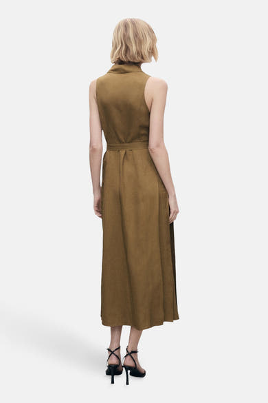 Robe kaki de MANGO, coupe midi, avec ceinture assortie et des sandales à talons noirs.
