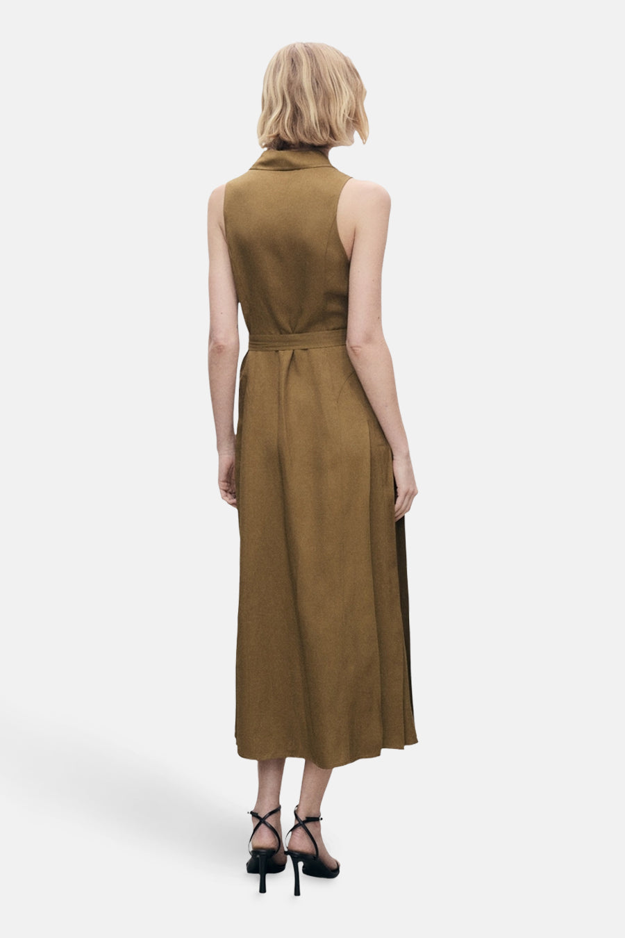 Robe kaki de MANGO, coupe midi, avec ceinture assortie et des sandales à talons noirs.
