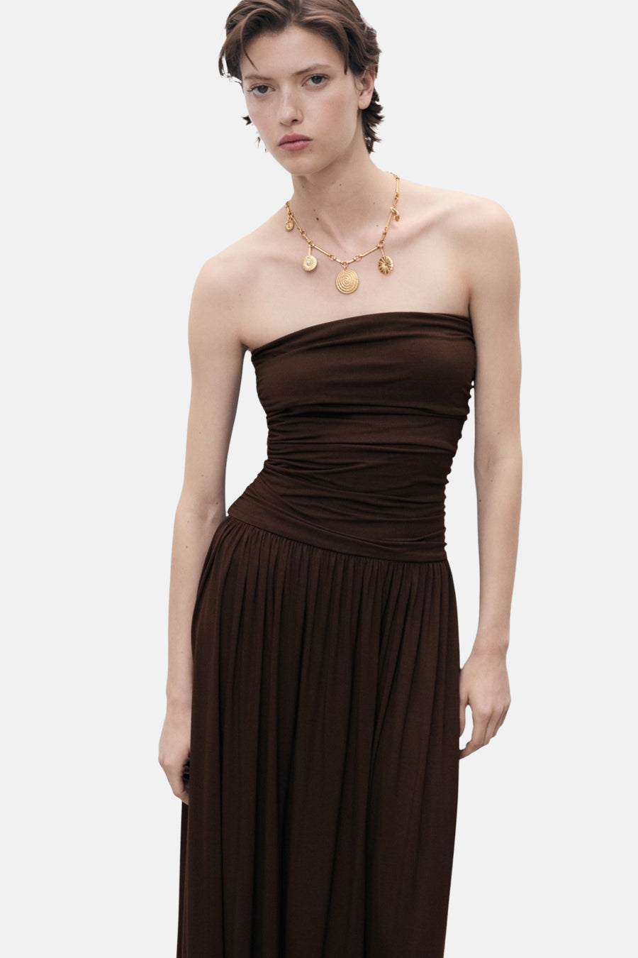 Bruine buisjurk van MANGO, met een gouden ketting met bedeltjes.