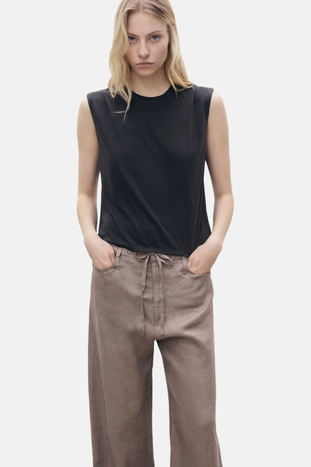 Zwart mouwloos topje van MANGO, gedragen met een high-waist broek van canvas.