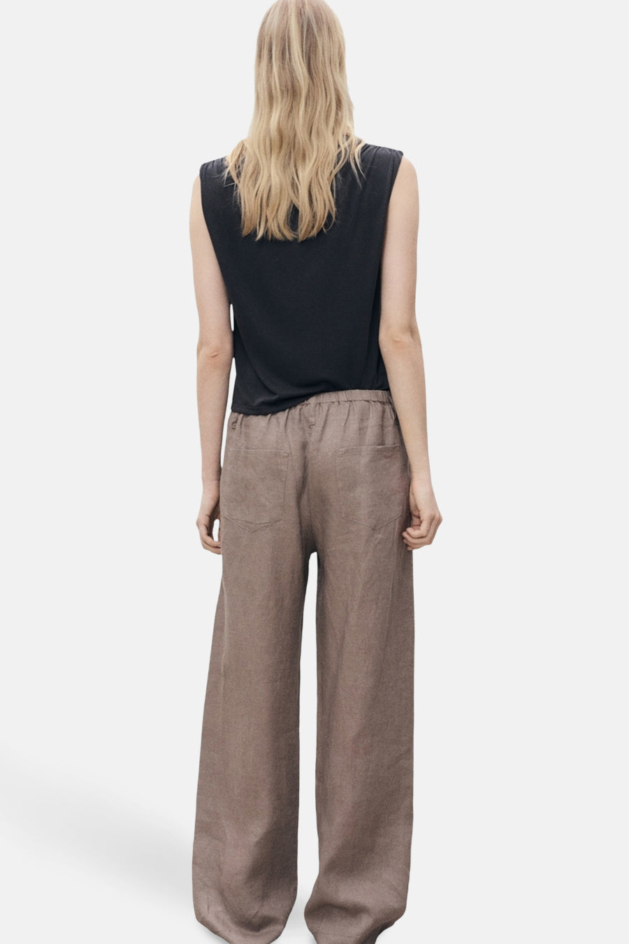 Zwart mouwloos topje van MANGO, gedragen met een wijde beige broek.
