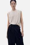 Beige mouwloze top van MANGO, met een effen achterkant en gedragen met een zwarte broek.