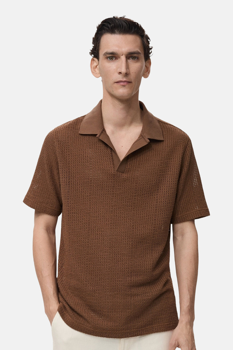 Bruin poloshirt met korte mouwen van MANGO, in ajourbreisel, gedragen met een lichte broek.