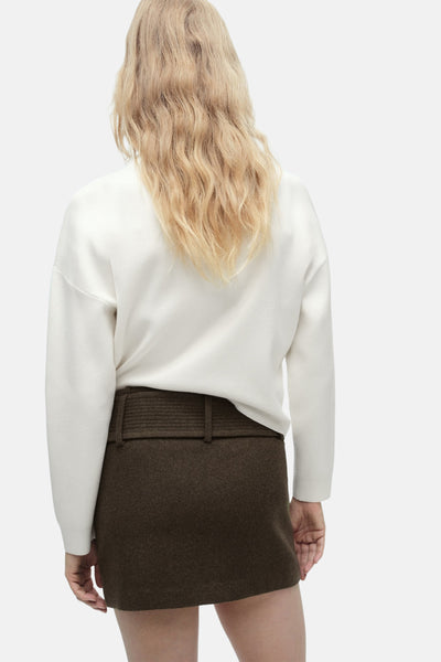 Witte ronde nekpull van MANGO, gedragen met een bruine wollenneep.