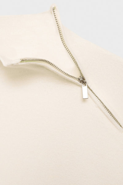 Witte ronde nekpull van MANGO, met een zichtbare diagonale knoop en rand in tricot.