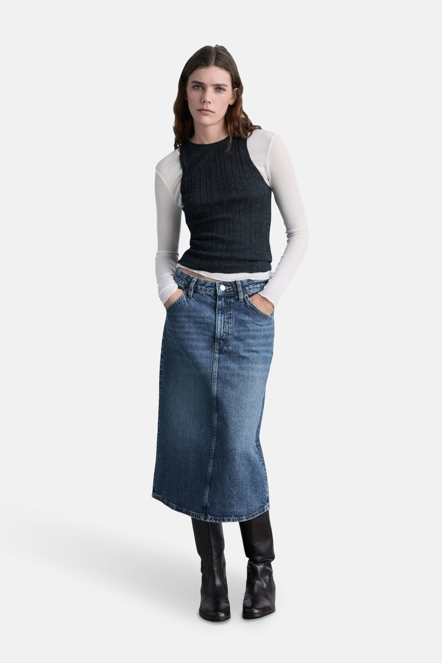Midi-jeansrok van lichtblauw denim van MANGO, gedragen met een zwarte geribbelde top en leren laarzen.