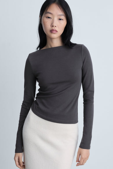 Grijze lange mouw T-shirt van MANGO, gedragen met een roomkleurige rok, rugweergave.