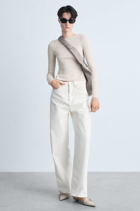 Beige lange mouw T-shirt van MANGO, gedragen met een crossbody tas en een witte broek.