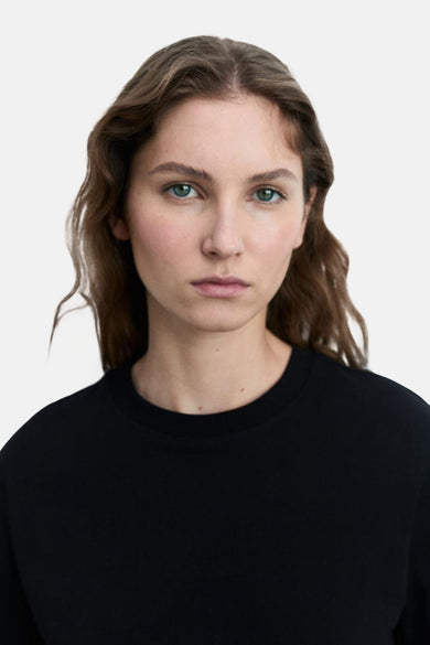 Zwarte t-shirt met korte mouwen van MANGO, gedragen door een vrouw met groene ogen.