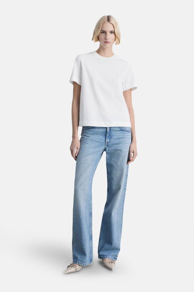 Wit T-shirt met korte mouwen van MANGO, gedragen met een spijkerbroek en pumps.