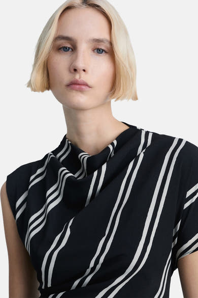 Zwarte jurk met verticale strepen, van MANGO, met een asymmetrische gedrapeerde halslijn en een lengte boven de knie.