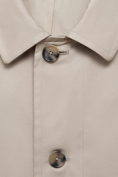 Grijze MANGO jas met een geknoopte kraag en een discrete knoopsluiting.