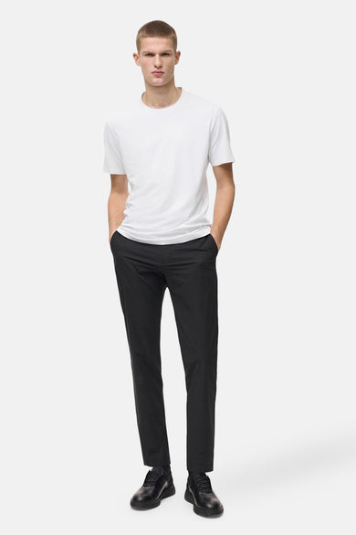 T-shirt blanc à manches courtes de MANGO, porté avec un pantalon noir et des chaussures assorties.