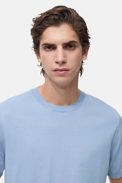 T-shirt bleu clair à manches courtes de MANGO, porté par un homme à la peau claire.