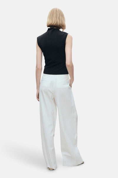 Zwart mouwloos topje van MANGO, gedragen met een gestreepte broek met hoge taille.