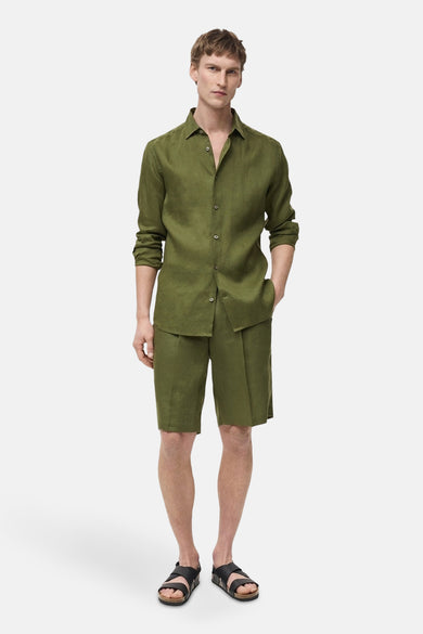 Short vert de MANGO, porté avec une chemise verte assortie et des sandales noires.