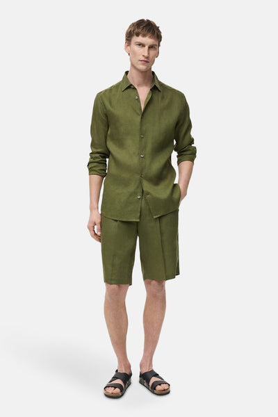 Short vert de MANGO, porté avec une chemise verte assortie et des sandales noires.