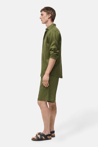 Korte groene MANGO top, gedragen met een bijpassend groen overhemd en gekruiste leren sandalen, zijaanzicht.