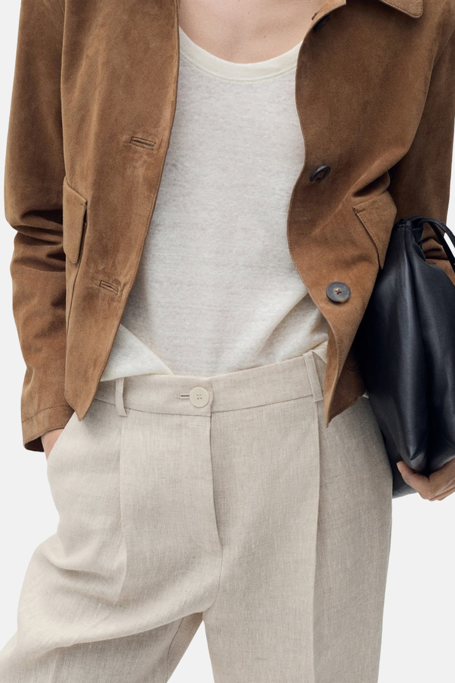 Beige broek van MANGO, rechte pasvorm met een persvouw aan de voorkant, gedragen met een T-shirt en een suède jasje.