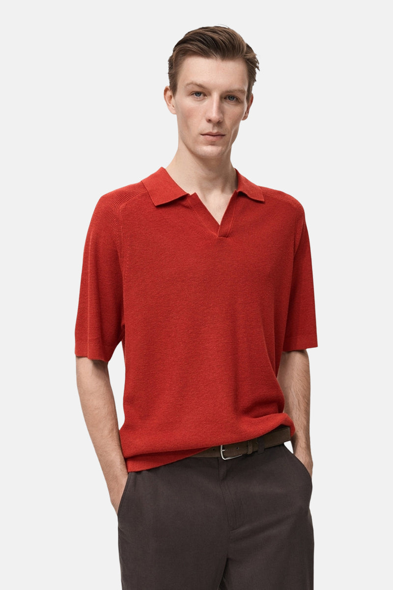 Rood poloshirt met korte mouwen van MANGO, in een getextureerde stof, gedragen met een bruine broek.