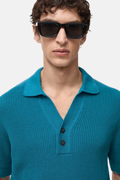 Polo à manches courtes turquoise par MANGO, avec deux boutons et texture tricotée.