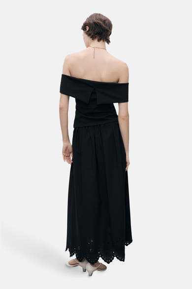 Jupe longue noire de MANGO, avec taille froncée et ourlet à broderie anglaise.