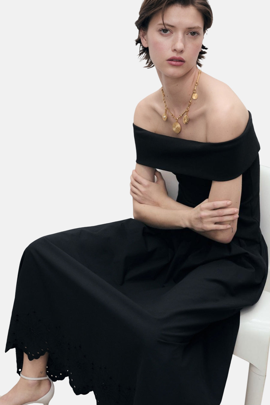 Zwarte lange rok van MANGO, met kanten uitgesneden details aan de zoom, gedragen met een gouden ketting.