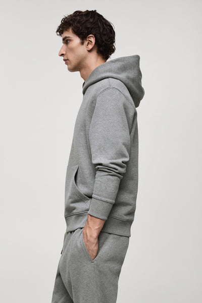Grijze hoodie van MANGO, met een kangoeroezak en gedragen met een bijpassende joggingbroek.