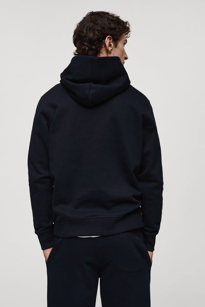 Blauwe hoodie van MANGO, van achteren gezien, gedragen met een bijpassende joggingbroek.