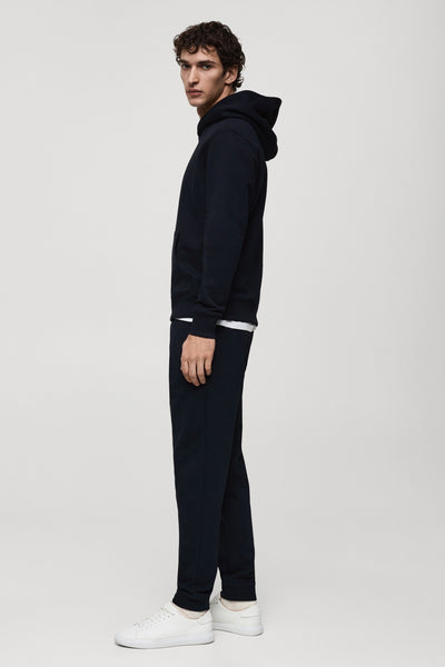 Blauwe hoodie van MANGO, gedragen met een wit T-shirt en een blauwe joggingbroek.