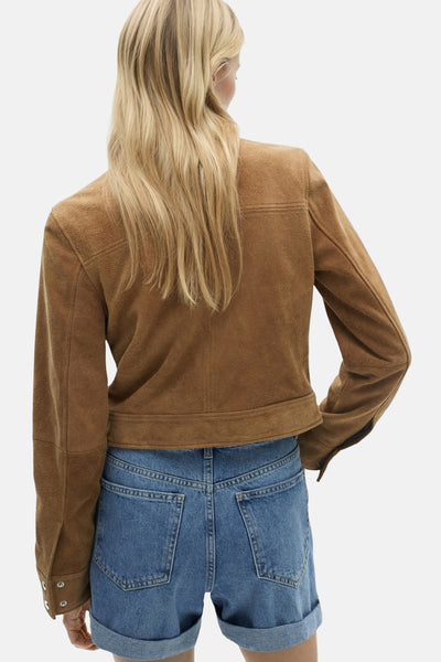 Short en denim bleu moyen de MANGO, porté avec une veste en daim marron.