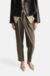 Kaki broek van MANGO, met een wijde pasvorm en platte sandalen met bandjes.