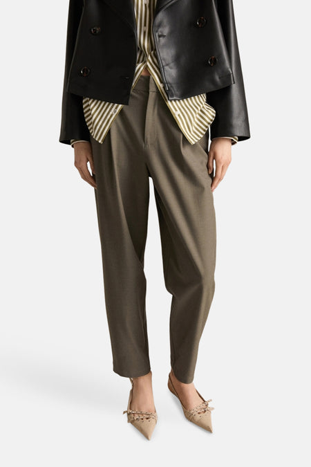 Kaki broek van MANGO, met een wijde pasvorm en platte sandalen met bandjes.