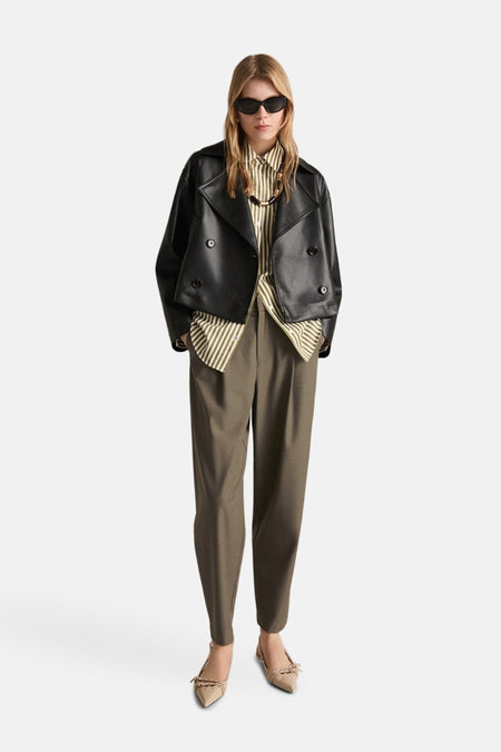 Kaki broek van MANGO, pantalonstijl met een groen gestreept overhemd en een zwart leren jasje.