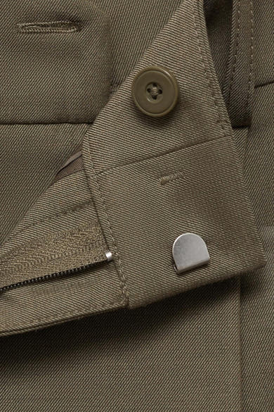 Kaki broek van MANGO, met ritssluiting en olijfkleurige knoop, close-up.