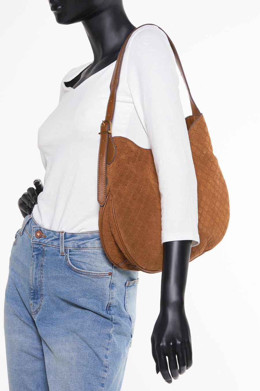 Bruine schoudertas van MANGO, met textuurpatroon, gedragen door een model met een spijkerbroek en een wit T-shirt.