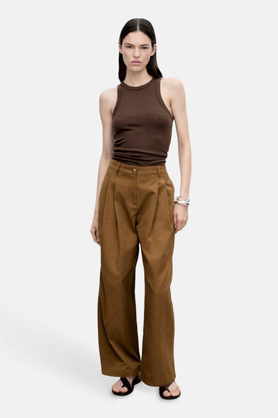 Bruin hemdje van MANGO, gedragen met een bruine, wijde, geplooide broek en zwarte sandalen.