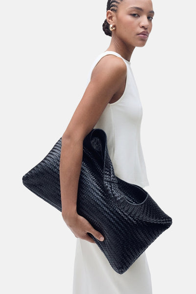Top blanc sans manches de MANGO, porté avec un pantalon blanc, et des boucles d'oreilles dorées.