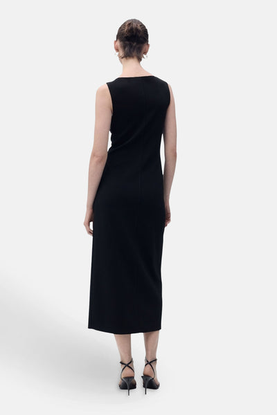 Zwarte jurk van MANGO, halflang recht model, naaddetail op de rug, gedragen met zwarte naaldhakken.