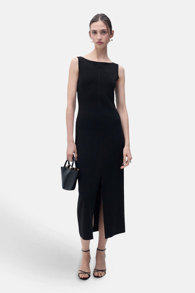 Zwarte MANGO jurk, midi-model met split, gedragen met sandalen met bandjes en een kleine handtas.