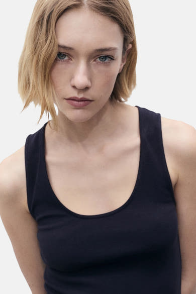 Blauwe jurk van MANGO, effen, gedragen door een vrouw met kort blond haar, op een witte achtergrond.