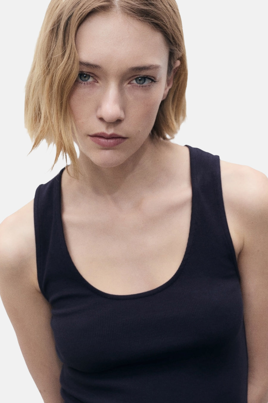 Blauwe jurk van MANGO, effen, gedragen door een vrouw met kort blond haar, op een witte achtergrond.