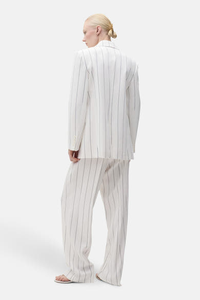 Pantalon de costume blanc à rayures fines de MANGO, coupe droite, porté avec une veste coordonnée.