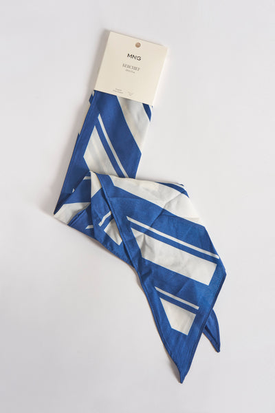 Foulard bleu à rayures, de MANGO, avec emballage en carton beige.