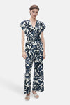 Multikleurige jumpsuit van MANGO, met tropische bladprint, strikceintuur en V-hals.