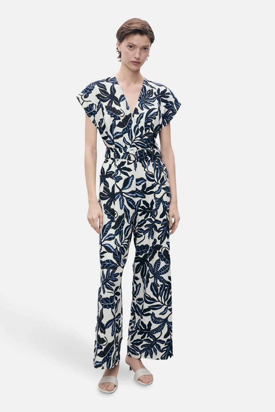 Multikleurige jumpsuit van MANGO, met tropische bladprint, strikceintuur en V-hals.