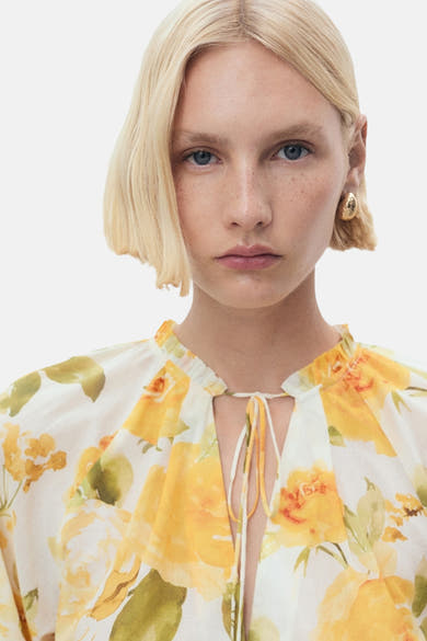 Chemisier à manches longues multicolore de MANGO, avec imprimé floral jaune et col à cordon.