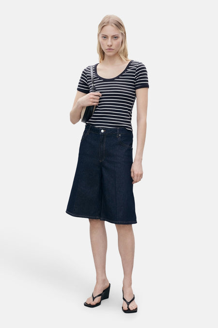 Blauw T-shirt met korte mouwen van MANGO, wit gestreept, gedragen met een spijkerbroek met korte pijpen en zwarte sandalen.
