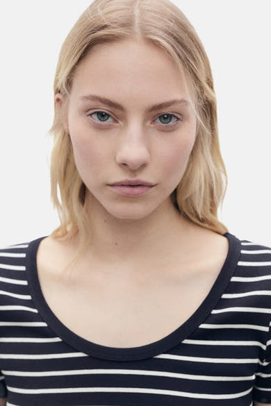 Blauw T-shirt met korte mouwen van MANGO, met witte horizontale strepen, gedragen door een vrouw.